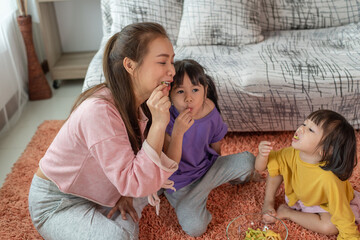 Happy Asian family mother and child daughter are enjoys eating snacks