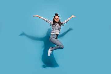 Fototapeta na wymiar Full length profile side photo of young excited african girl happy positive smile jump up isolated over blue color background