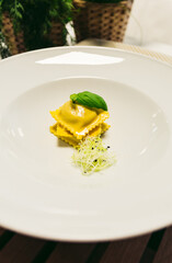 Tomato soup or gazpacho soup with Ravioli and basil on a wooden rustic table - preparing process.