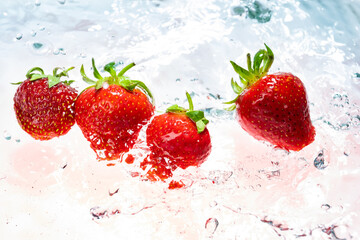 fresh natural strawberries on light background with splashing water