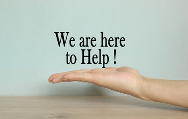 WE ARE HERE TO HELP. hand on a blue background. Business, financial, marketing concept.