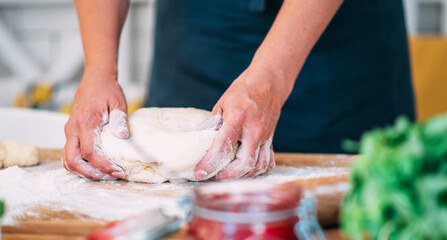 Female making dough. Dough, flour with accessories for the bakingin the composition on the kitchen table.