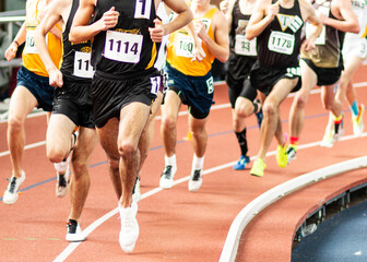 Runners racing the mile on an indoor track