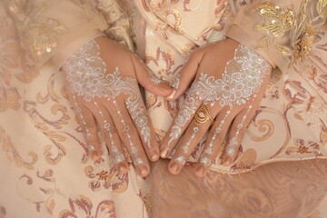 Asian bride's hands with henna patterns and art on white henna color