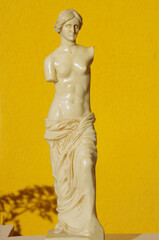 Scale reproduction of the statue of Venus de Milo on an orange background