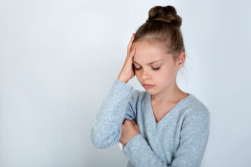 Little girl holding her head.