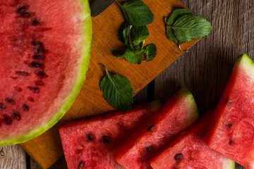 Refreshing watermelon on a rustic wooden background. Slices of juicy ripe red watermelon.
