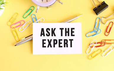 Top view of a business card with text ASK THE EXPERT, on a yellow background.