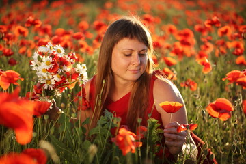 Girl in a field with a bouquet of daisies and poppies