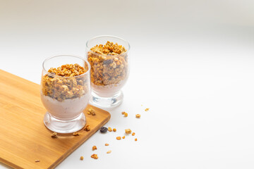 granola in a glass, muesli, healthy breakfast on a white plate