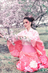 Beuatiful girl wearing japanese traditional kimono in  orchard during spring
