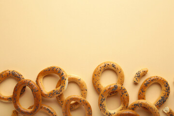 Whole bagel with poppy seeds on beige background with copy space
