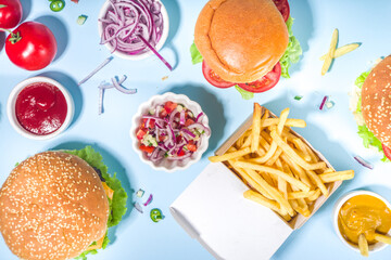 Fastfood, burger party concept. Various delicious burgers set with french fries and sauces on bright blue background flatlay top view copy space