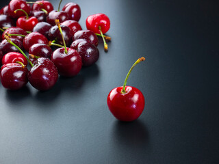 the best cherry choice among the group of cherries, the best fruit selection concept, red fruit luxury on black slate