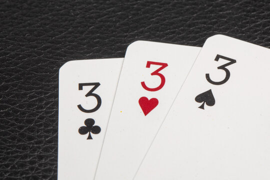 the number three on 3 different playing card suits
