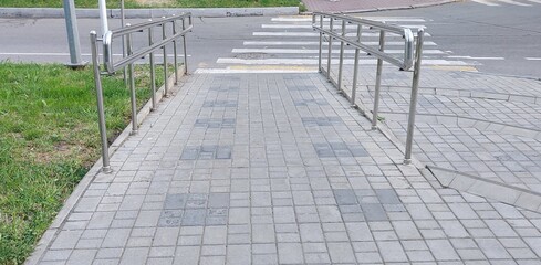 Metal ramp for the disabled leading to the pedestrian crossing.