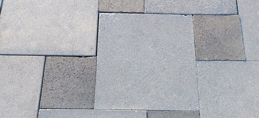 The paving slabs are gray, square, close-up.