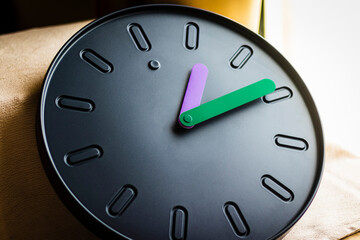 Close up shot of a clock with colorful hands.Indoors
