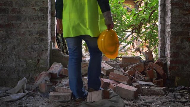 Worker in demolished building with hard hat 