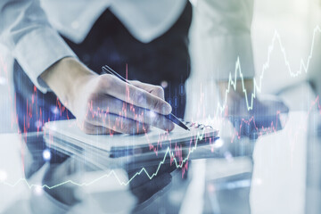 Double exposure of abstract creative financial diagram with hand writing in notebook on background, banking and accounting concept