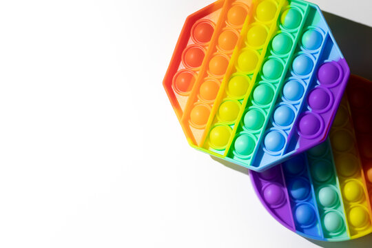 Pop It silicone sensory anti-stress Fidget kid toys colorful rainbow game isolated on white background, copy text space. Calming tools, adult stress reliever popping, trendy push bubble toys