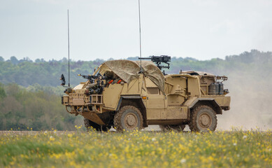 British army Supacat Jackal MWMIK rapid assault, fire support and reconnaissance vehicle in action on a military battle exercise, Wilts UK