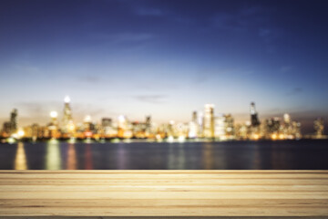 Fototapeta na wymiar Blank wooden tabletop with beautiful blurry skyline at night on background, mockup