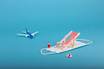 Beach chairs isolated on a Coronavirus covid 19 face mask and blue background