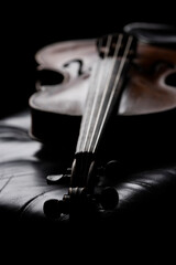 A viola or violin on a leather bench in a moody environment