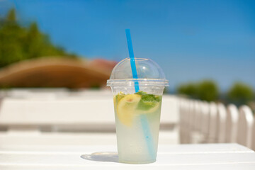 cold water glass with lemon on sea open cafe in hot summer day. shallow depth of field photo