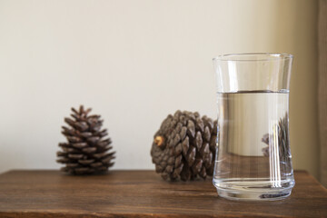 Glass with water on a wooden table close-up.
