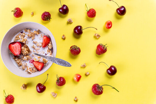 Multigrain wholewheat healthy cereals with fresh berry for breakfast overhead shot.Granola with yogurt and blueberry, cherries.Organic muesli with fresh fruits and yorgurt