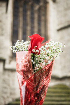 Close-up of a bousquet of flowers with a cathedral stairs and window in the background