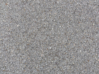 Grainy background of tiny flat stones in different shapes and neutral colors compacted to create a tile. Outdoor flooring