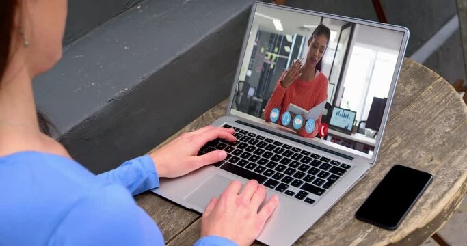Caucasian businesswoman sitting at desk using laptop having video call with female colleague