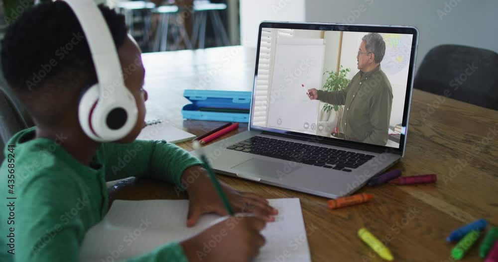 Sticker African american boy doing homework while having a video call with male teacher on laptop at home