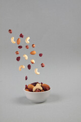 fruit mix pouring into a bowl isolated on gray background - flying food concept