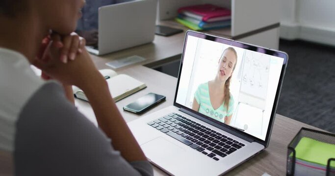 Mid section of african american woman having a video call with female colleague on laptop at office