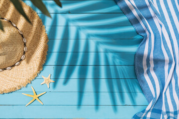 Hat, starfishes and towel on a blue background, summer background