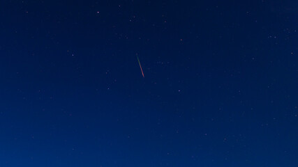 Obraz na płótnie Canvas Bright red-green meteor of Perseid flow in the night sky