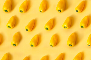 Pattern of yellow bell peppers on yellow background.