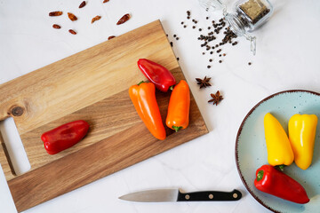 Background of food on a white marble table. Spices and knife on a wooden cutting board, top view, flat