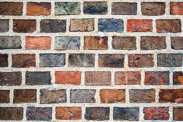 Old masonry of multicolored bricks in different shades of red and black