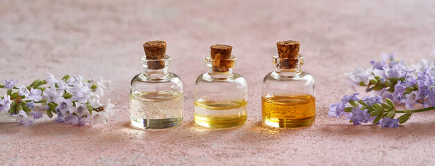 Panoramic header of bottles of essential oil with fresh lavender. Aromatherapy concept.