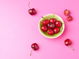 Bowl of fresh cherries on a pink background