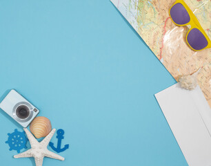 Summer travel flet lay background, made with different shells, camera, modern colorful sunglasses, map and white envelope.   Creative copyspace. © Lelija