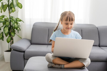 Full size photo of amazed child sit folded crossed legs work computer get social media notification