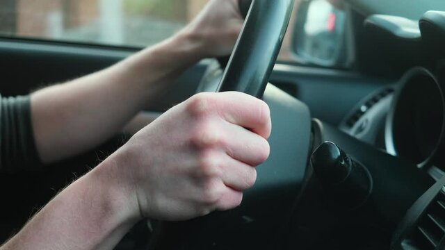Car steering wheel turns. The concept of driving, driving on the road. Hands on the steering wheel close-up.