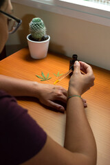 Woman pouring CBD oil on her skin. Using CBD extract, natural skin care product made with cannabis.