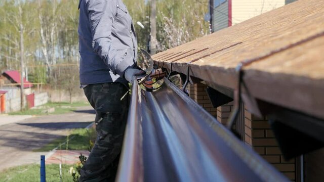 Installation of a gutter. Roofing works in a private house.